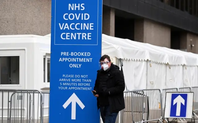 A person walks next to a Covid vaccine centre