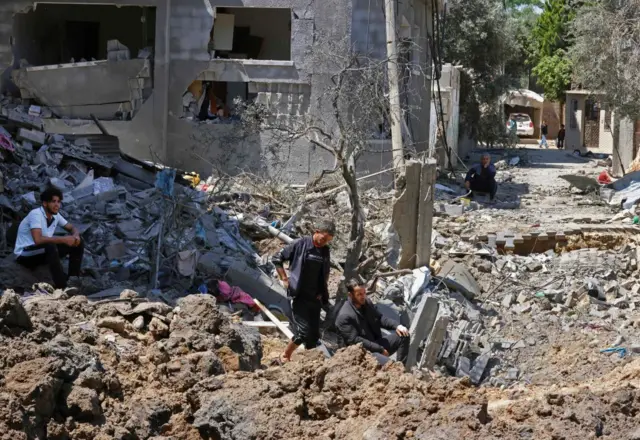 Palestinians assess the damage caused by Israeli air strikes, in Beit Hanun in the northern Gaza Strip