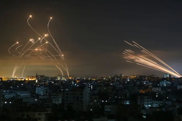 Rockets are seen in the night sky fired towards Israel from Beit Lahia in the northern Gaza Strip on 14 May 2021