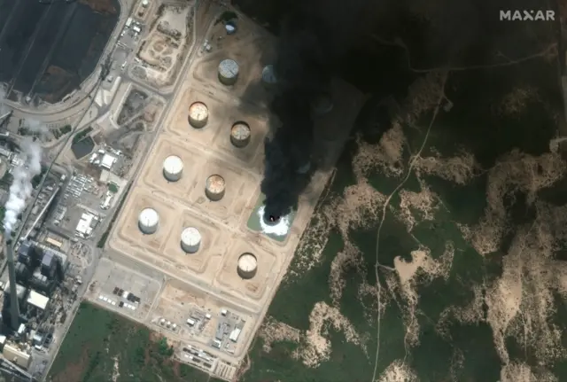 A handout satellite image made available by MAXAR Technologies shows a closer view of burning storage tank in Southern Israel, 12 May 2021 (issued on 13 May 2021)