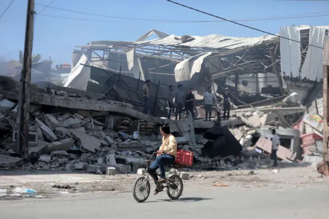 Palestinians inspect a building destroyed in Israeli air strike in Gaza City