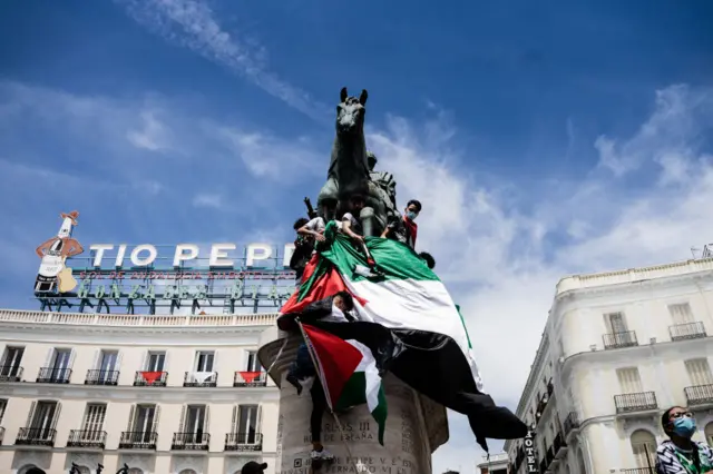 Protester unfurl a giant Palestinian flag on the statue of Carlos III in Plaza del Sol at the demonstration in Madrid, Spain, on May 15, 2021