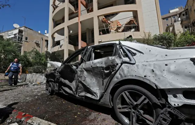 Members of the Israeli security and emergency services work on a site hit by a rocket in Ramat Gan near the coastal city of Tel Aviv, on 15 May 2021