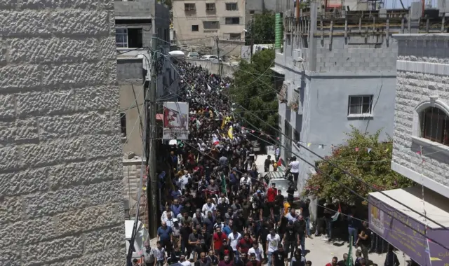 Palestinian mourners carry the body of Yaseen Hamad