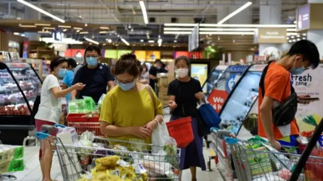 People in Singapore shop for groceries ahead of restrictions