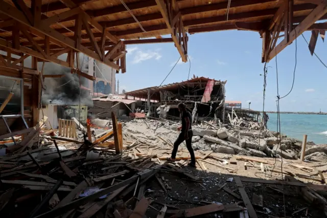 A Palestinian man walks through a building in Gaza City damaged in an Israeli strike on 17 May 2021