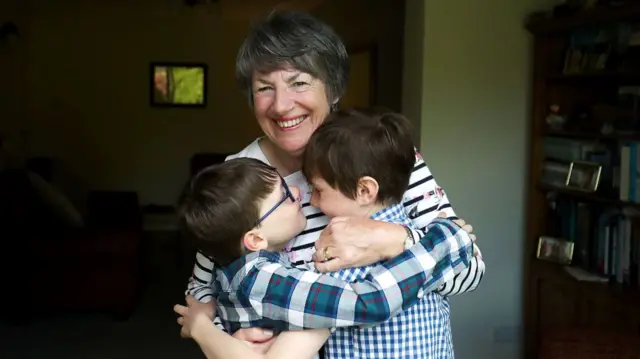 Sue Rickett hugs her grandchildren Ben (right) and Isaac (left) for the first time in over a year