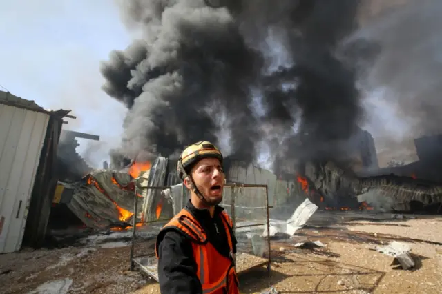 A Palestinian firefighter reacts as he participates in efforts to put out a fire at a sponge factory after it was hit by Israeli artillery shells, according to witnesses, in the northern Gaza Strip May 17, 2021.