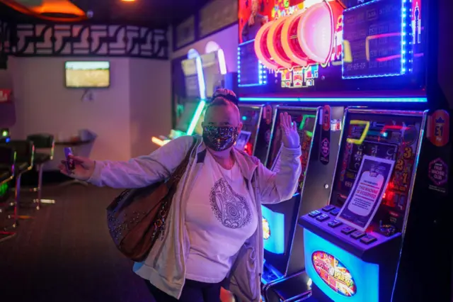 Woman celebrates returning to a bingo hall in Rhyl, Denbighshire, as Covid restrictions ease