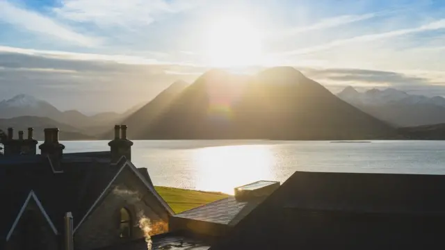 A view from Raasay Distillery of the sun setting behind the mountain Glamaig on Skye.