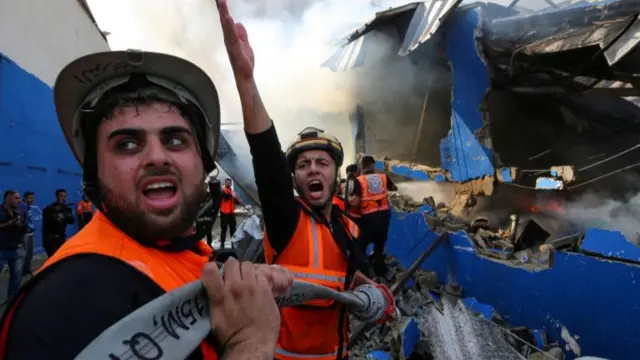 A Palestinian firefighter reacts as tries to put out a fire at a sponge factory in Gaza reportedly hit by Israeli artillery shells (17 May 2021)after it was hit by Israeli artillery shells, according to witnesses, in the northern Gaza Strip May 17, 2021