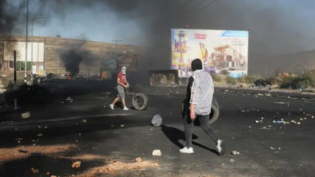 Palestinians take part in a protest in al-Bireh, near Ramallah, in the occupied West Bank (18 May 2021)