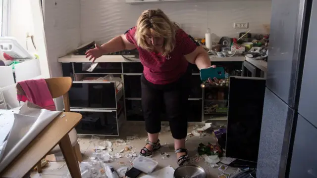 Victoria Tapalashvili can be seen inspecting the damage at her home in the southern Israeli city of Ashdod following an attack.