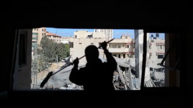 A Palestinian man standing among rubble in Gaza