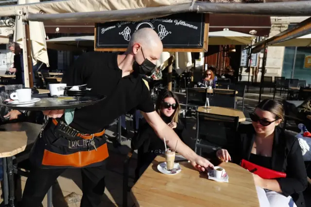 A waiter serves coffee during the reopening of terraces of restaurants and bars in Montpellier, France