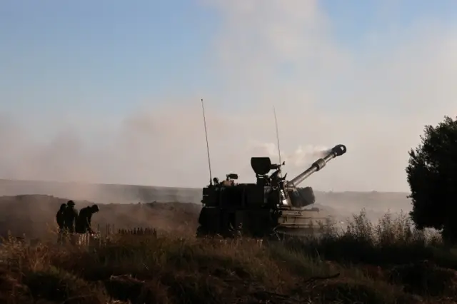 Israeli soldiers work at an artillery unit