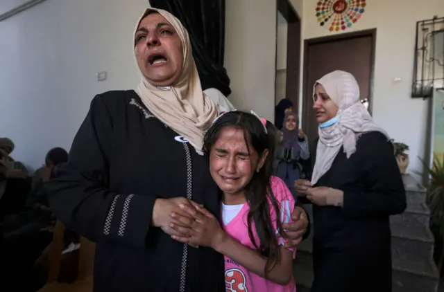 The sister (R) and relatives of Palestinian Mahmoud Shtawi, 19, cry during his funeral on May 19, 2021