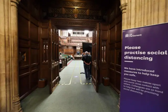 Commons chamber with signs about social distancing