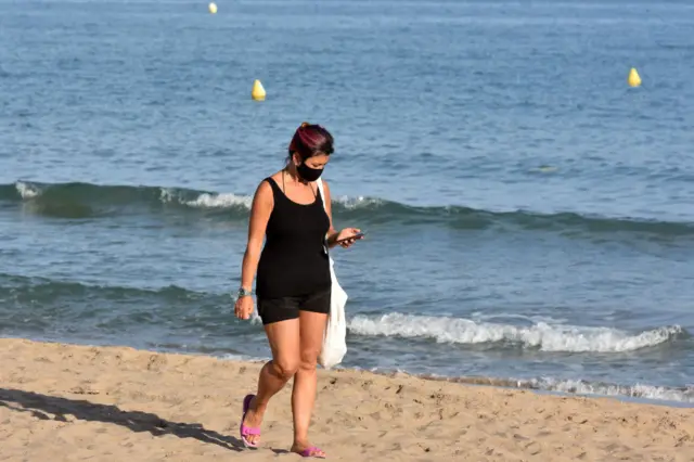 A woman walking on a beach in Spain