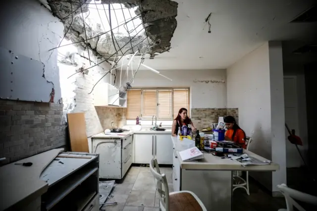 Family members of the Vaizel family in their damaged home in Israel