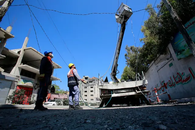 Palestinian electricity workers seen as they try to fix damaged cables