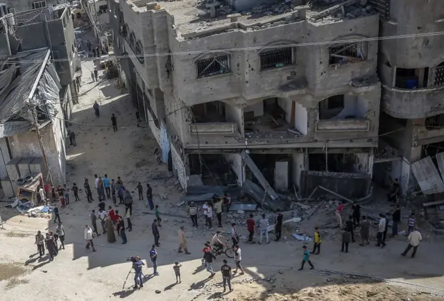 Palestinians inspect their destroyed house