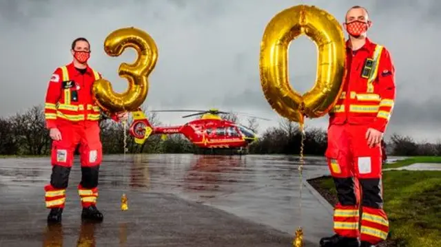 Two Midlands Air Ambulance staff holding balloons