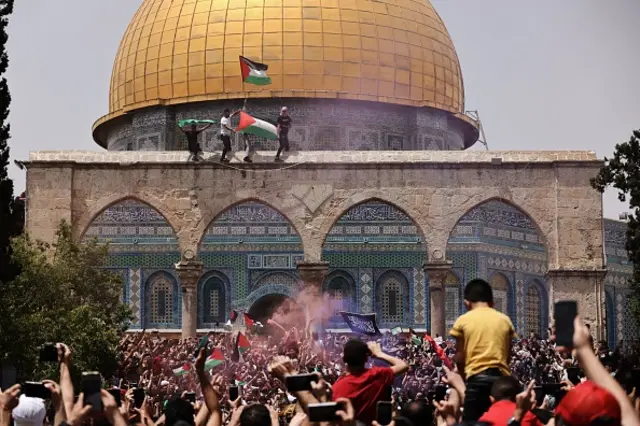 Palestinian Muslim worshippers wave the Palestinian and the Hamas flag during clashes with Israeli security forces in Jerusalem's al-Aqsa mosque compound, the third holiest site of Islam, on May 21, 2021