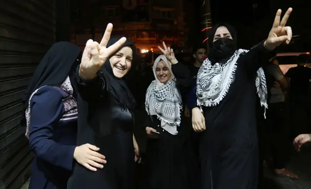 Women make peace signs at demonstration in Gaza