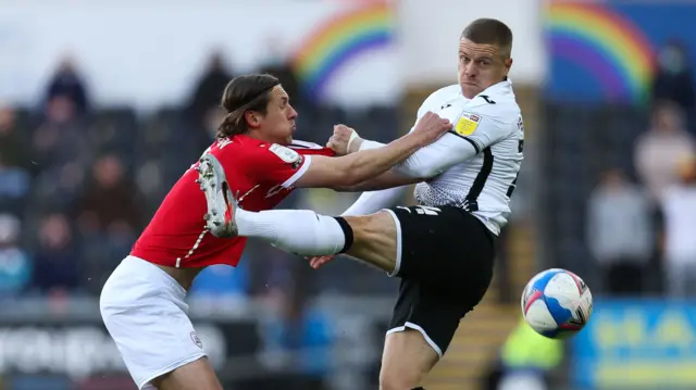 Jake Bidwell heads away ball