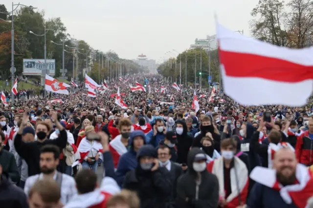 People waving flags attend an opposition rally, September 2020