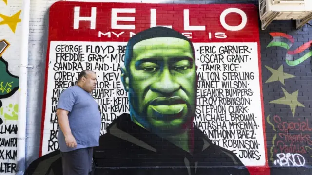 A person walks past a mural for George Floyd in the Brooklyn borough of New York