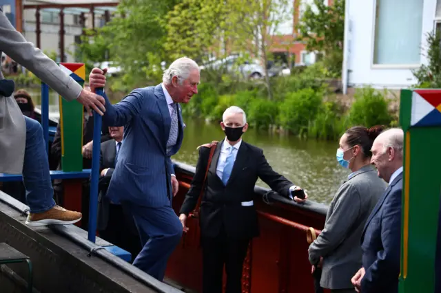 The Prince of Wales boards the heritage boat "Scorpio" as he views the Coventry Canal