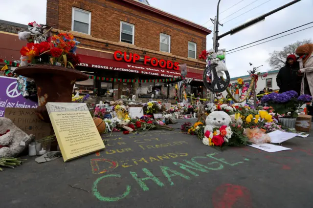 People lay flowers at a memorial in George Floyd Square in Minneapolis, Minnesota, United States on April 21, 2021