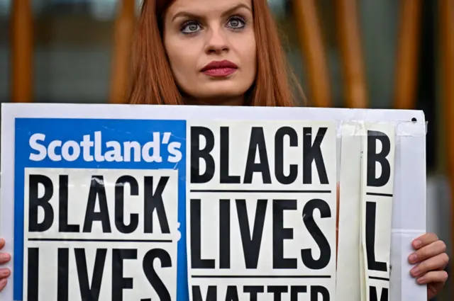 Members of the public gather outside the Scottish Parliament to mark the first anniversary of Georg Floyd’s death on May 25, 2021 in Edinburgh, Scotland