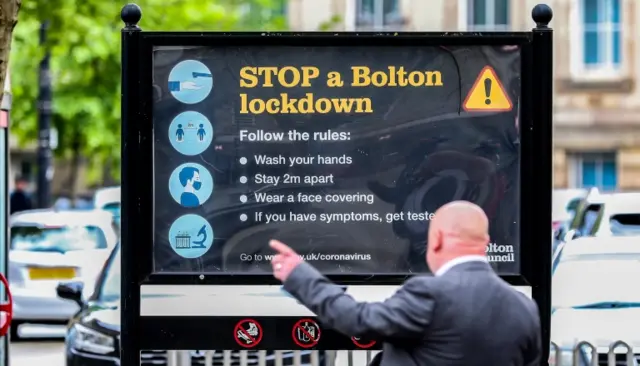 A sign in Bolton with public health messaging on it