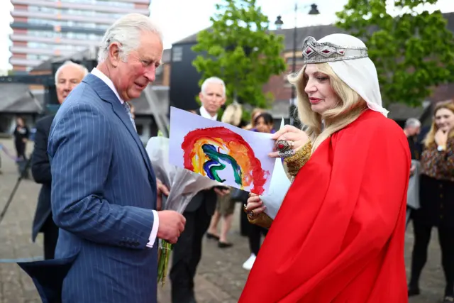 The Prince of Wales meets with Pru Porretta, who is dressed up to represent Lady Godiva, during his visit to the Canal Basin, in Coventry