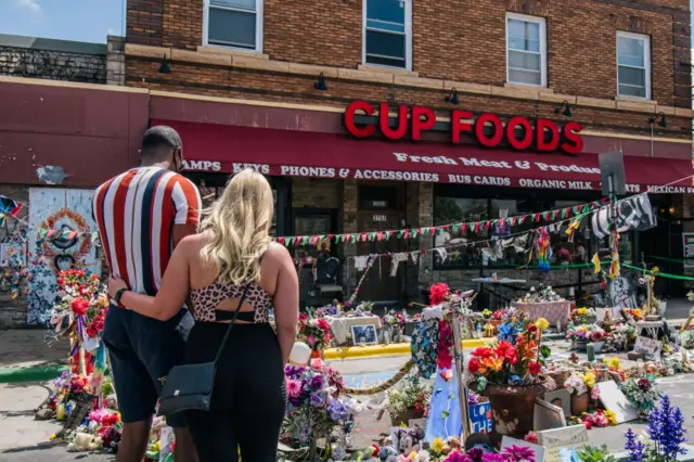 A couple pays respects near where Floyd was killed