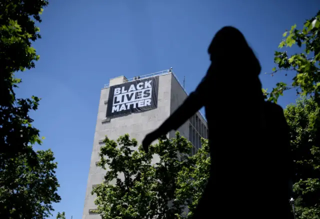 A person walks past the US Embassy in Spain where they have hung a banner in support of the 'Black Lives Matter' movement, on 25 May, 2021 in Madrid, Spain