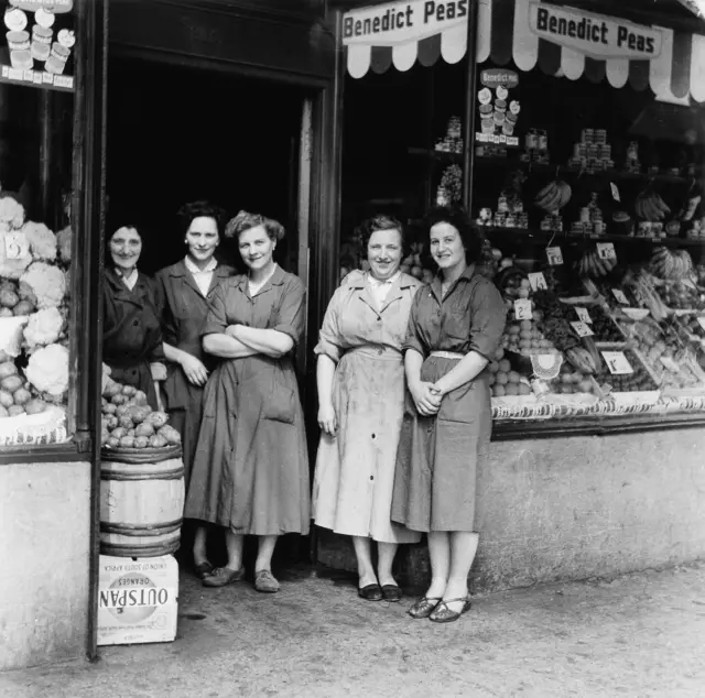 Women standing outside a greengrocers shop