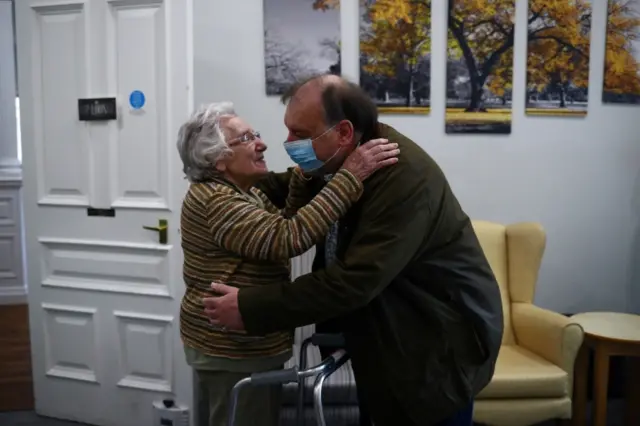 A care home resident hugging her son