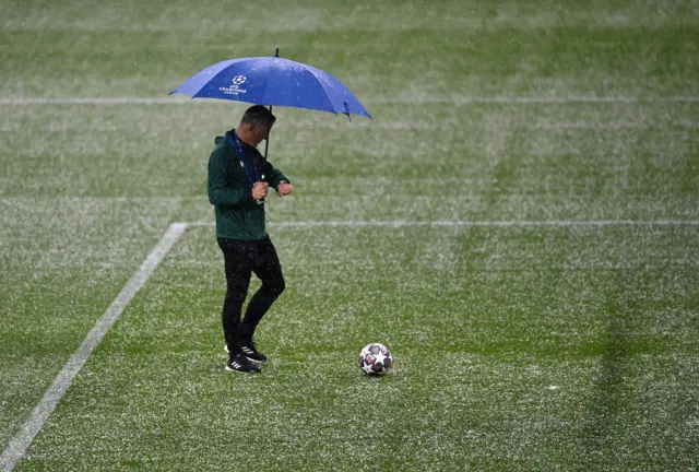 Match officials check the condition of the Etihad pitch