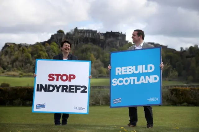 Ruth Davidson and Douglas Ross hold up placards in front of Stirling Castle