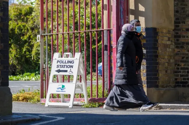 Voters leave a polling station in Tower Hamlets, London