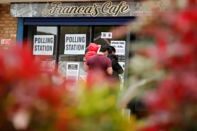 People queue outside a polling station during local elections in Oxford