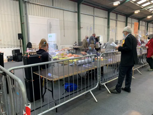 Voting verification with plastic barriers up for Covid