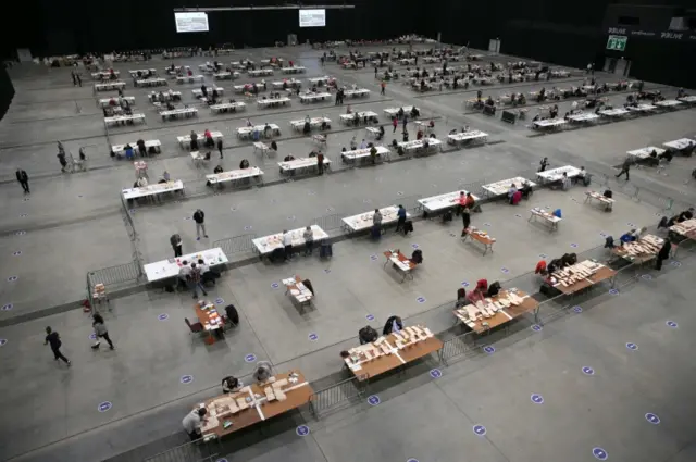 Votes being counted in a huge room in Scotland, with over 80 desks with pairs of vote-counters sat on each