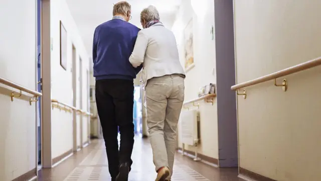 Two people walking in a care home