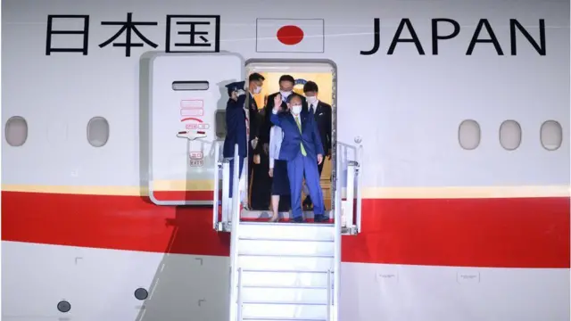 Japanese Prime Minister Yoshihide Suga steps off a plane at Cornwall Airport