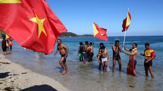 Demonstrators hold Tigray"s flags as they gather by the sea at Gyllyngvase beach after a Tigray protest in Falmouth, during the G7 summit in Cornwall, Britain,